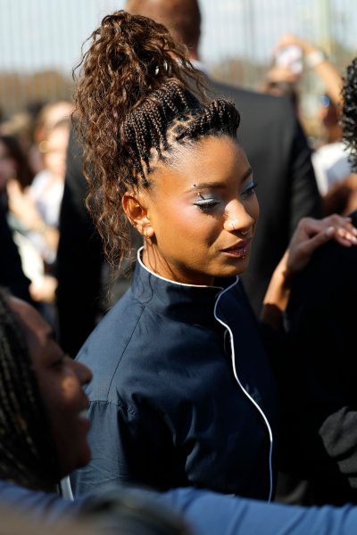 Willow Smith appears at the Dior show wearing a navy jacket and a braided updo.